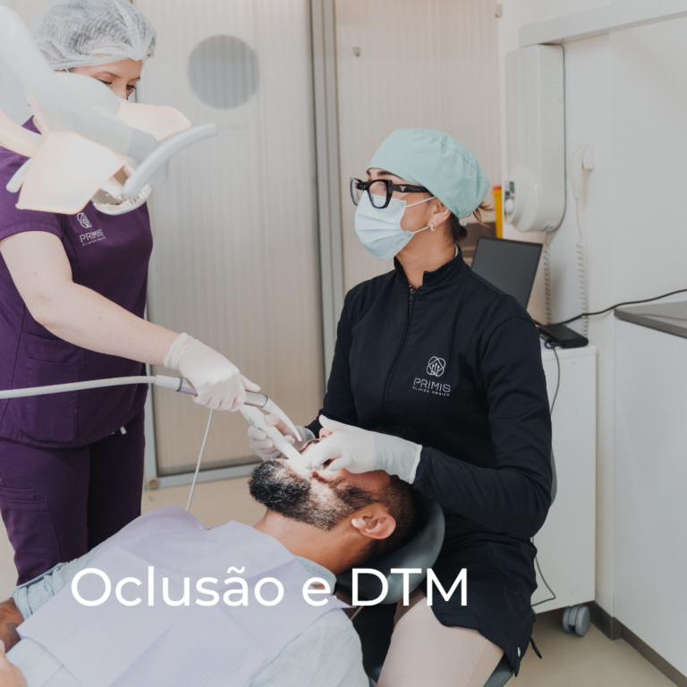 Consulta de oclusão e DTM na Primis — médica dentista a examinar um paciente com apoio de assistente