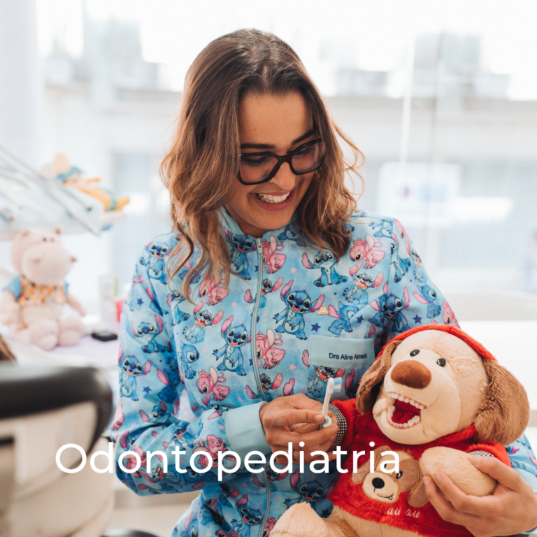 Dra. Aline Almeida a demonstrar a escovagem dentária com um peluche numa consulta de odontopediatria